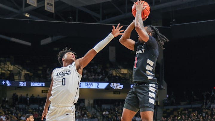 Feb 5, 2025; Orlando, Florida, USA; Cincinnati Bearcats guard Day Day Thomas (1) shoots the ball over UCF Knights guard Jordan Ivy-Curry (0) during the first half at Addition Financial Arena. Mandatory Credit: Mike Watters-Imagn Images