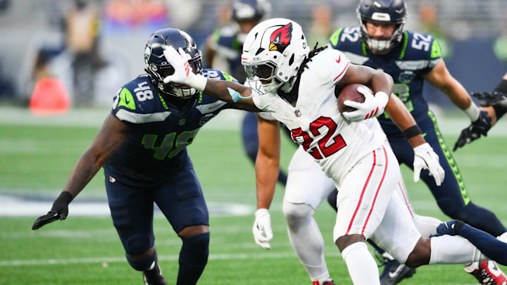 Nov 9, 2025; Seattle, Washington, USA; Arizona Cardinals running back Michael Carter (22) rushes and stiff arms Seattle Seahawks linebacker Tyrice Knight (48) during the fourth quarter at Lumen Field. Mandatory Credit: Steven Bisig-Imagn Images