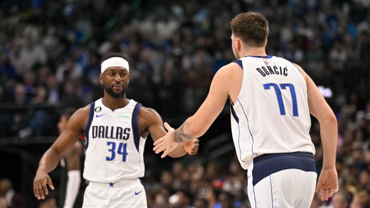 Dec 29, 2022; Dallas, Texas, USA; Dallas Mavericks guard Luka Doncic (77) greets guard Kemba Walker (34) as Walker enters the game against the Houston Rockets during the first half at the American Airlines Center. Mandatory Credit: Jerome Miron-USA TODAY Sports