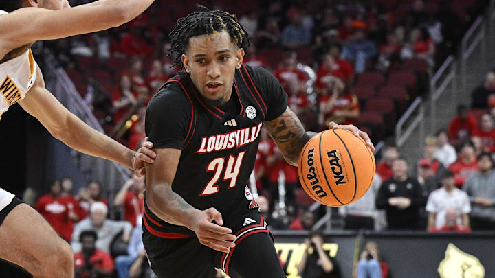 Nov 22, 2024; Louisville, Kentucky, USA; Louisville Cardinals guard Chucky Hepburn (24) dribbles against Winthrop Eagles guard Paul Jones III (3) during the second half at KFC Yum! Center. Louisville defeated Winthrop 76-61. 