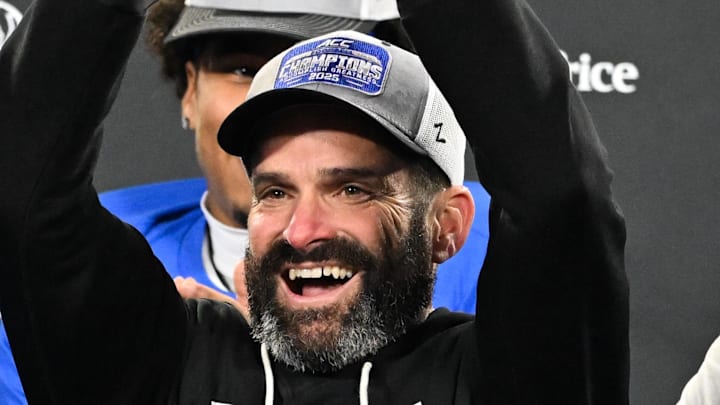 Dec 6, 2025; Charlotte, NC, USA; Duke Blue Devils head coach Manny Diaz lifts the ACC trophy with offensive lineman Justin Pickett (77) and defensive tackle Aaron Hall (99) after defeating the Virginia Cavaliers at the 2025 ACC Championship game at Bank of America Stadium. Mandatory Credit: Bob Donnan-Imagn Images Dec 6, 2025; Charlotte, NC, USA; Duke Blue Devils head coach Manny Diaz lifts the ACC trophy with offensive lineman Justin Pickett (77) and defensive tackle Aaron Hall (99) after defeating the Virginia Cavaliers at the 2025 ACC Championship game at Bank of America Stadium. Mandatory Credit: Bob Donnan-Imagn Images