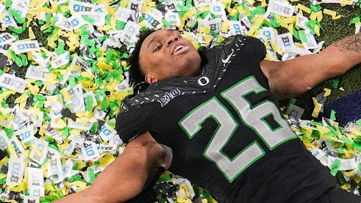 Oregon Ducks linebacker Devon Jackson (26) makes a confetti angel on Sunday, Dec. 8, 2024, after the Big Ten Championship game at Lucas Oil Stadium in Indianapolis. The Oregon Ducks defeated the Penn State Nittany Lions, 45-37.