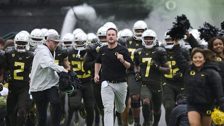 Nov 4, 2023; Eugene, Oregon, USA; Oregon Ducks head coach Dan Lanning runs out to the field with players before a game against the California Golden Bears at Autzen Stadium. Mandatory Credit: Troy Wayrynen-Imagn Images Nov 4, 2023; Eugene, Oregon, USA; Oregon Ducks head coach Dan Lanning runs out to the field with players before a game against the California Golden Bears at Autzen Stadium. Mandatory Credit: Troy Wayrynen-Imagn Images