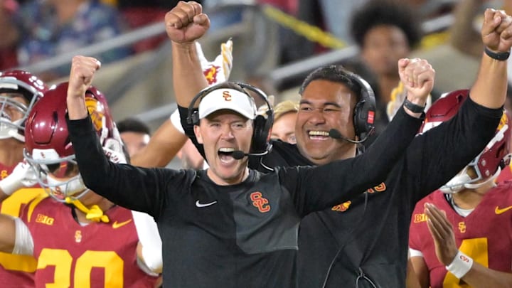 Oct 11, 2025; Los Angeles, California, USA;  USC Trojans head coach Lincoln Riley (wearing white visor) celebrates along with defensive end coach Shaun Nua after kicker Ryon Sayeri (48) hit a 54-yard field goal in the second half against the Michigan Wolverines at United Airlines Field at the Los Angeles Memorial Coliseum. 