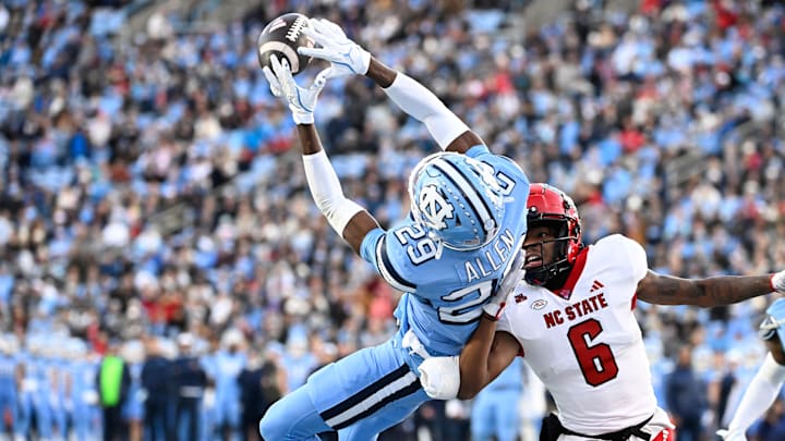 Nov 30, 2024; Chapel Hill, North Carolina, USA; North Carolina Tar Heels defensive back Marcus Allen (29) intercepts the ball in the end zone intended for North Carolina State Wolfpack wide receiver Wesley Grimes (6) in the first quarter at Kenan Memorial Stadium. Mandatory Credit: Bob Donnan-Imagn Images