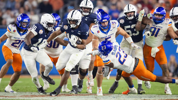 Penn State football running back Nicholas Singleton (10) rushes for a touchdown against diving Boise State Broncos safety Seyi Oladipo (23) during the Fiesta Bowl at State Farm Stadium
