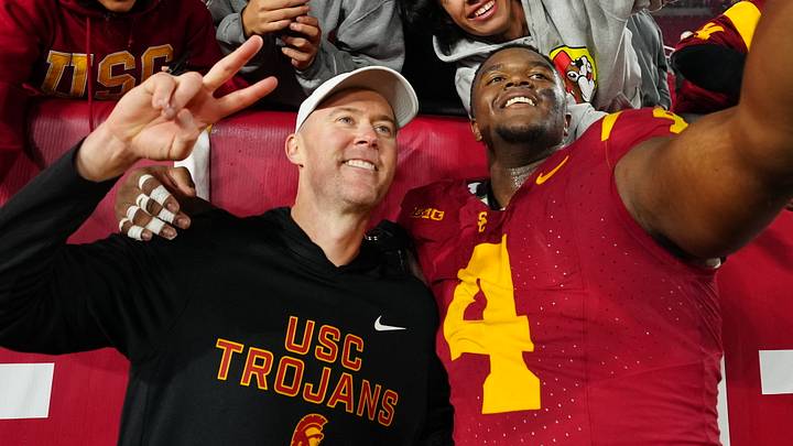 Nov 29, 2025; Los Angeles, California, USA; Southern California Trojans head coach Lincoln Riley (right) and defensive tackle Jahkeem Stewart (4) pose with fans after the game against the UCLA Bruins at United Airlines Field at Los Angeles Memorial Coliseum. Mandatory Credit: Kirby Lee-Imagn Images Nov 29, 2025; Los Angeles, California, USA; Southern California Trojans head coach Lincoln Riley (right) and defensive tackle Jahkeem Stewart (4) pose with fans after the game against the UCLA Bruins at United Airlines Field at Los Angeles Memorial Coliseum. Mandatory Credit: Kirby Lee-Imagn Images