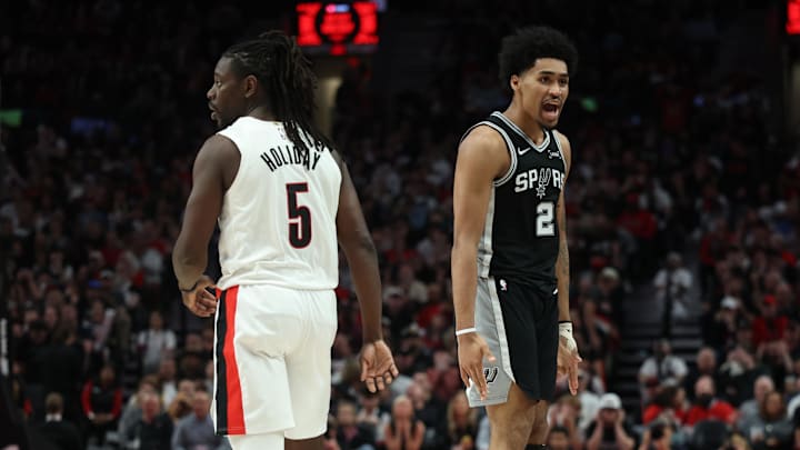 Apr 24, 2026; Portland, Oregon, USA; San Antonio Spurs guard Dylan Harper (2) reacts after scoring against Portland Trail Blazers guard Jrue Holiday (5) during the second half during Game 3 of the first round of the 2026 NBA Playoffs at Moda Center.