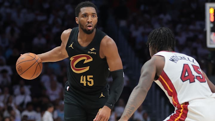 Apr 26, 2025; Miami, Florida, USA; Cleveland Cavaliers guard Donovan Mitchell (45) dribbles the basketball as Miami Heat guard Davion Mitchell (45) defends in the first quarter during game three for the first round of the 2025 NBA Playoffs at Kaseya Center. Mandatory Credit: Sam Navarro-Imagn Images