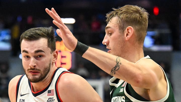 Oct 28, 2025; Hartford, CT, USA; Connecticut Huskies forward Alex Karaban (11) drives to the basket against Michigan State Spartans center Carson Cooper (15) during the first half at PeoplesBank Arena.
