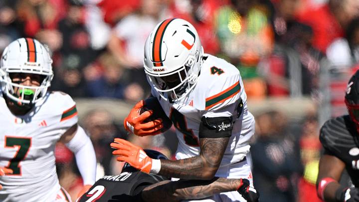Oct 19, 2024; Louisville, Kentucky, USA; Miami Hurricanes running back Mark Fletcher Jr. (4) runs the ball against Louisville Cardinals defensive back Tamarion McDonald (12) during the first half at L&N Federal Credit Union Stadium. Miami defeated Louisville 52-45. Mandatory Credit: Jamie Rhodes-Imagn Images Oct 19, 2024; Louisville, Kentucky, USA; Miami Hurricanes running back Mark Fletcher Jr. (4) runs the ball against Louisville Cardinals defensive back Tamarion McDonald (12) during the first half at L&N Federal Credit Union Stadium. Miami defeated Louisville 52-45. Mandatory Credit: Jamie Rhodes-Imagn Images