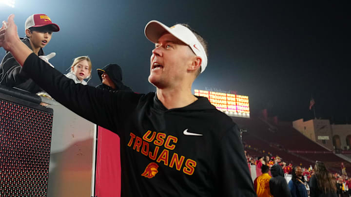 Nov 29, 2025; Los Angeles, California, USA; Southern California Trojans head coach Lincoln Riley celebrates with fans after the game against the UCLA Bruins at United Airlines Field at Los Angeles Memorial Coliseum. Mandatory Credit: Kirby Lee-Imagn Images
