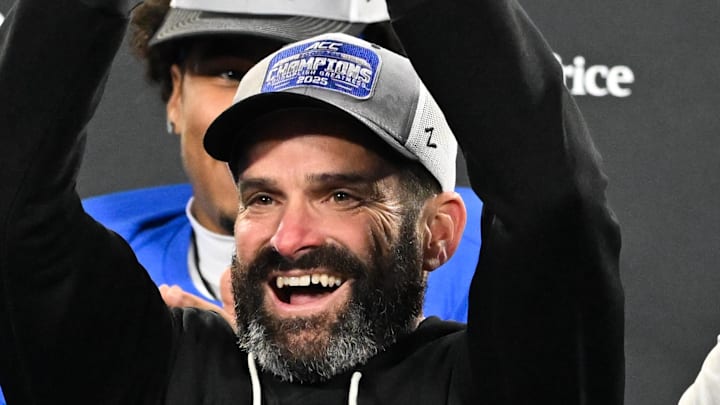 Dec 6, 2025; Charlotte, NC, USA; Duke Blue Devils head coach Manny Diaz lifts the ACC trophy with offensive lineman Justin Pickett (77) and defensive tackle Aaron Hall (99) after defeating the Virginia Cavaliers at the 2025 ACC Championship game at Bank of America Stadium. Mandatory Credit: Bob Donnan-Imagn Images