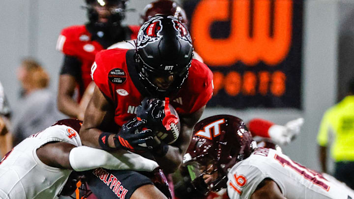 Sep 27, 2025; Raleigh, North Carolina, USA; North Carolina State Wolfpack wide receiver Terrell Anderson (9) is tackled by Virginia Tech Hokies cornerback Isaiah Brown-Murray (9), and linebacker Noah Chambers (16) during the first half of the game against Virginia Tech Hokies at Carter-Finley Stadium. Mandatory Credit: Jaylynn Nash-Imagn Images