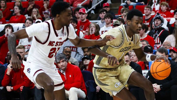 Jan 17, 2026; Raleigh, North Carolina, USA; Georgia Tech Yellow Jackets guard Lamar Washington (1) dribbles with the ball guarded by NC State Wolfpack guard Terrance Arceneaux (21) during the first half of the game at Lenovo Center. Mandatory Credit: Jaylynn Nash-Imagn Images