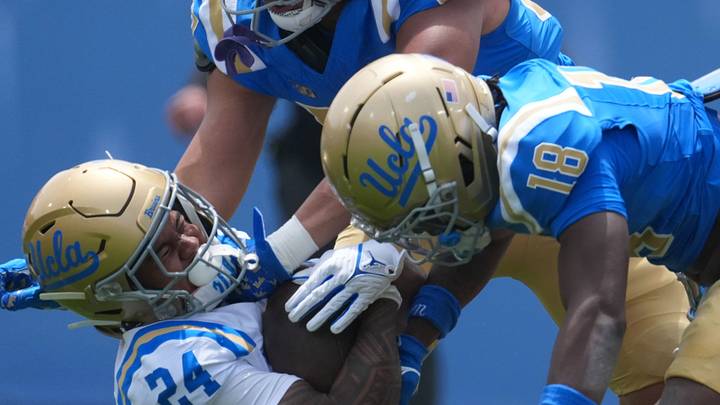 May 2, 2026; Pasadena, CA, USA; UCLA Bruins linebacker Matthew Muasau (57) and defensive backs Osiris Gilbert (18) and Cole Martin (4) tackle receiver Jonah Smith (24) during the spring game at Rose Bowl. Mandatory Credit: Kirby Lee-Imagn Images May 2, 2026; Pasadena, CA, USA; UCLA Bruins linebacker Matthew Muasau (57) and defensive backs Osiris Gilbert (18) and Cole Martin (4) tackle receiver Jonah Smith (24) during the spring game at Rose Bowl. Mandatory Credit: Kirby Lee-Imagn Images