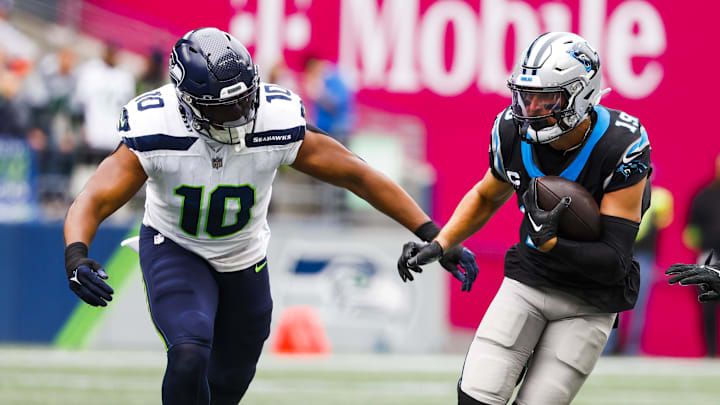 Sep 24, 2023; Seattle, Washington, USA; Carolina Panthers wide receiver Adam Thielen (19) runs for yards after the catch against Seattle Seahawks linebacker Uchenna Nwosu (10) during the first quarter at Lumen Field. 