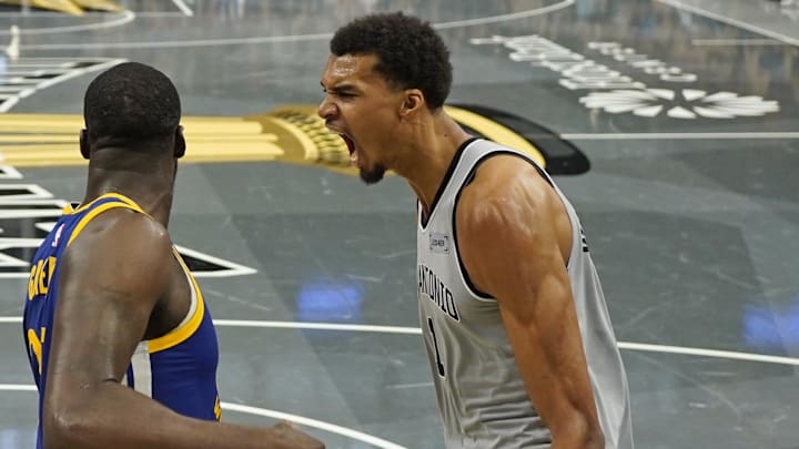 Nov 14, 2025; San Antonio, Texas, USA; San Antonio Spurs forward Victor Wembanyama (1) reacts after dunking over Golden State Warriors forward Draymond Green (23) during the second half at Frost Bank Center. Mandatory Credit: Scott Wachter-Imagn Images