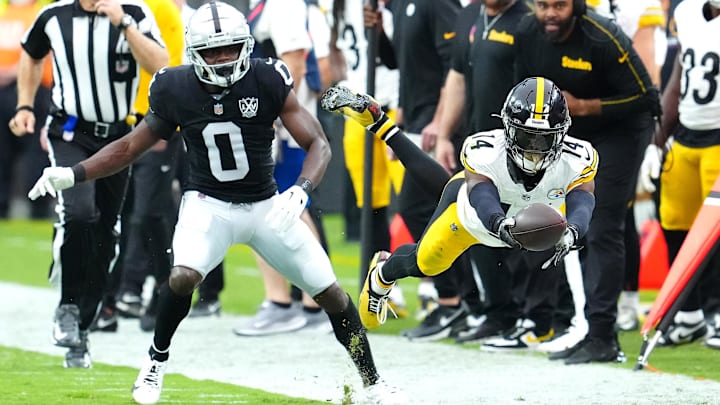 Oct 13, 2024; Paradise, Nevada, USA; Pittsburgh Steelers wide receiver George Pickens (14) dives for extra yardage after making a catch in front of Las Vegas Raiders cornerback Jakorian Bennett (0) during the first quarter at Allegiant Stadium. Mandatory Credit: Stephen R. Sylvanie-Imagn Images