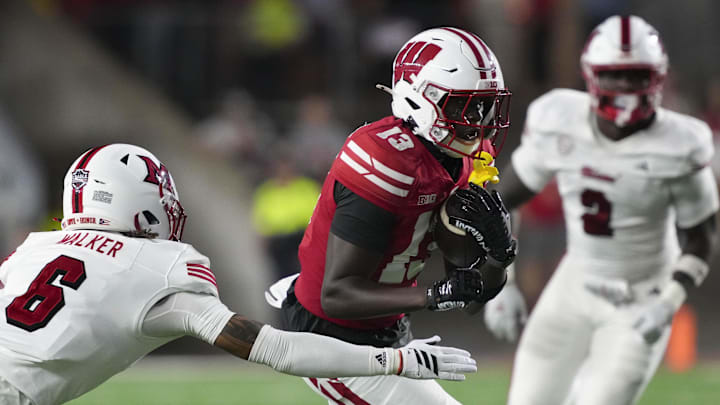 Aug 28, 2025; Madison, Wisconsin, USA; Wisconsin Badgers wide receiver Eugene Hilton Jr. (13) rushes with the football against Miami (OH) RedHawks defensive back Adrian Walker Jr. (6) during the third quarter at Camp Randall Stadium. Aug 28, 2025; Madison, Wisconsin, USA; Wisconsin Badgers wide receiver Eugene Hilton Jr. (13) rushes with the football against Miami (OH) RedHawks defensive back Adrian Walker Jr. (6) during the third quarter at Camp Randall Stadium.