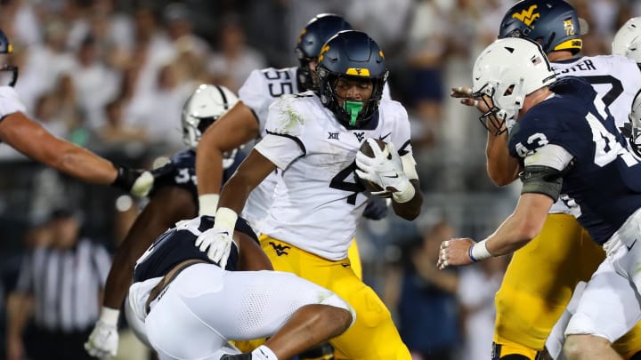 Sep 2, 2023; University Park, Pennsylvania, USA; West Virginia Mountaineers running back CJ Donaldson Jr. (4) runs the ball against the Penn State Nittany Lions during the fourth quarter at Beaver Stadium. Penn State won 38-15. Sep 2, 2023; University Park, Pennsylvania, USA; West Virginia Mountaineers running back CJ Donaldson Jr. (4) runs the ball against the Penn State Nittany Lions during the fourth quarter at Beaver Stadium. Penn State won 38-15.