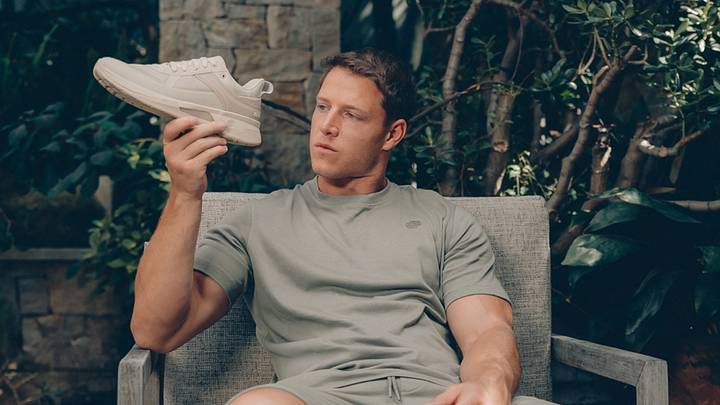 Christian McCraffrey holds his While On Earth training shoe. Christian McCraffrey holds his While On Earth training shoe.