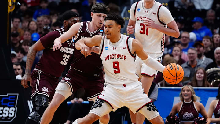Mar 20, 2025; Denver, CO, USA; Montana Grizzlies guard Kai Johnson (1) defends against Wisconsin Badgers guard John Tonje (9) during the first half in the first round of the NCAA Tournament at Ball Arena.