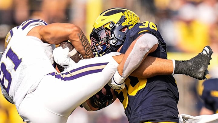 Michigan linebacker Jimmy Rolder (30) tackles Washington wide receiver Dezmen Roebuck (81) 