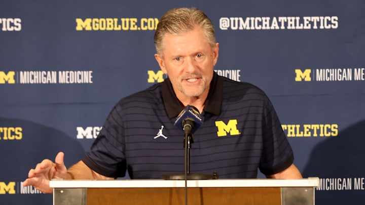 Kyle Whittingham speaks at a news conference introducing him as the new Michigan Wolverines head football coach at the Hyatt Regency Orlando on December 28, 2025 in Orlando, Florida. Kyle Whittingham speaks at a news conference introducing him as the new Michigan Wolverines head football coach at the Hyatt Regency Orlando on December 28, 2025 in Orlando, Florida.