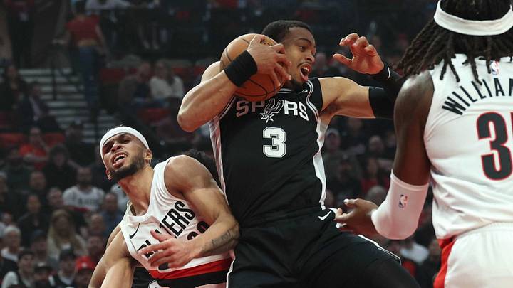 Apr 24, 2026; Portland, Oregon, USA; San Antonio Spurs forward Keldon Johnson (3) grabs a rebound over Portland Trail Blazers forward Toumani Camara (33) during the first half of Game 3 of the first round of the 2026 NBA Playoffs at Moda Center.