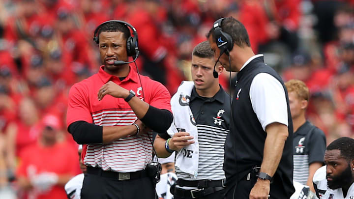 Cincinnati Bearcats defensive coordinator Marcus Freeman, left, stands next to head coach Luke Fickell during an injury timeout of a college football game against the Ohio State Buckeyes, Saturday, Sept. 7, 2019, at Ohio Stadium in Columbus