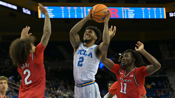 Feb 3, 2026; Los Angeles, California, USA;  UCLA Bruins guard Donovan Dent (2) is defended by Rutgers Scarlet Knights guard Lino Mark (2) and forward Chris Nwuli (11) as he drives to basket in the first half at Pauley Pavilion presented by Wescom Financial. Mandatory Credit: Jayne Kamin-Oncea-Imagn Images