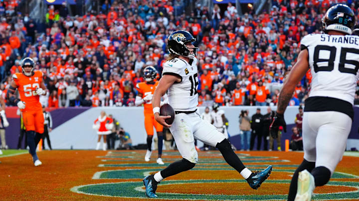 Dec 21, 2025; Denver, Colorado, USA; Jacksonville Jaguars quarterback Trevor Lawrence (16) rushes for a touchdown against the Denver Broncos during the second half at Empower Field at Mile High. Mandatory Credit: Ron Chenoy-Imagn Images