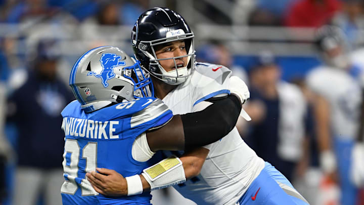 Tennessee Titans quarterback Mason Rudolph (11) gets pulled to the ground by Detroit Lions defensive end Levi Onwuzurike (91) 