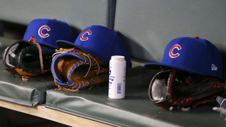 Detailed view of Chicago Cubs hats and gloves in the dugout