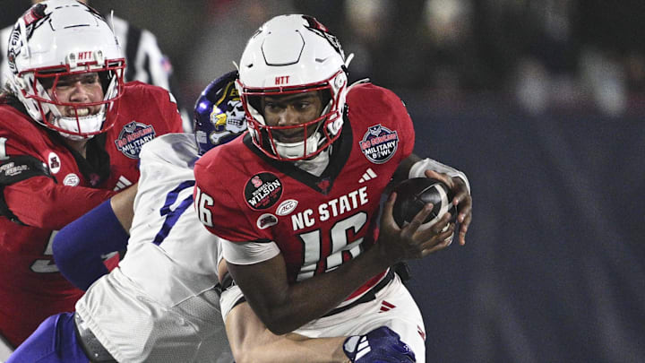 Dec 28, 2024; Annapolis, MD, USA;  East Carolina Pirates defensive lineman J.D. Lampley (9) sacks North Carolina State Wolfpack quarterback CJ Bailey (16) during the first half of the Go Bowling Military Bowl at Navy-Marine Corps Memorial Stadium. Mandatory Credit: Tommy Gilligan-Imagn Images