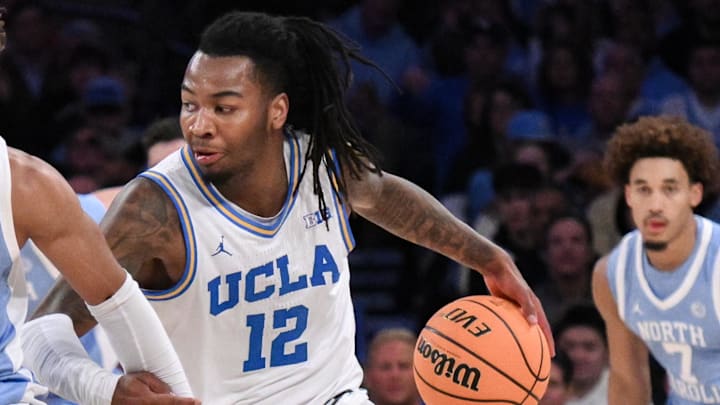 Dec 21, 2024; New York, NY, USA; UCLA Bruins guard Sebastian Mack (12) brings the ball up court while being defended by North Carolina Tar Heels guard RJ Davis (4) during the first half at Madison Square Garden. Mandatory Credit: John Jones-Imagn Images