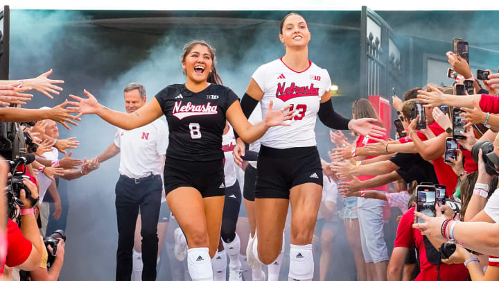 Aug 30, 2023; Lincoln, NE, USA; Nebraska Cornhuskers outside hitter Merritt Beason (13) and libero Lexi Rodriguez (8) run out of the tunnel before the match against the Omaha Mavericks at Memorial Stadium.