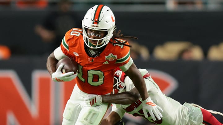 Oct 17, 2025; Miami Gardens, Florida, USA; Miami Hurricanes wide receiver Malachi Toney (10) carries the football against Louisville Cardinals defensive back Tayon Holloway (25) during the fourth quarter at Hard Rock Stadium. Mandatory Credit: Sam Navarro-Imagn Images