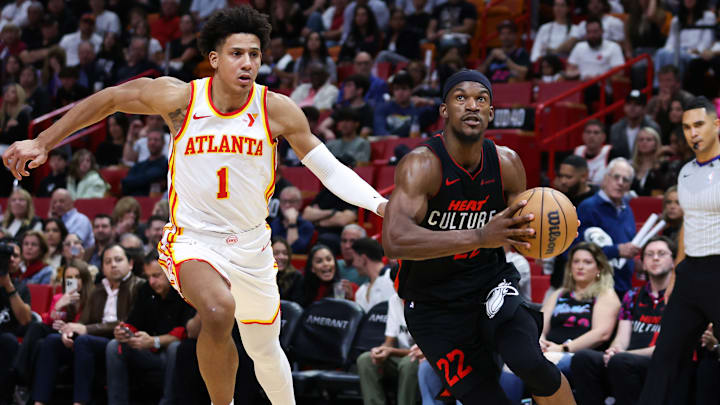 Jalen Johnson #1 of the Atlanta Hawks chases Jimmy Butler #22 of the Miami Heat.