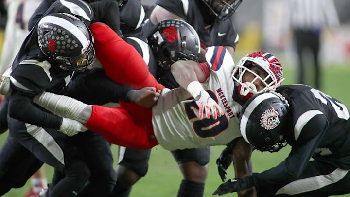 McKeesport's Kemon Spell (20) gets taken to the ground by multiple Aliquippa defenders during the second half of the WPIAL 4A Championship game Friday evening at Acrisure Stadium in Pittsburgh, PA.