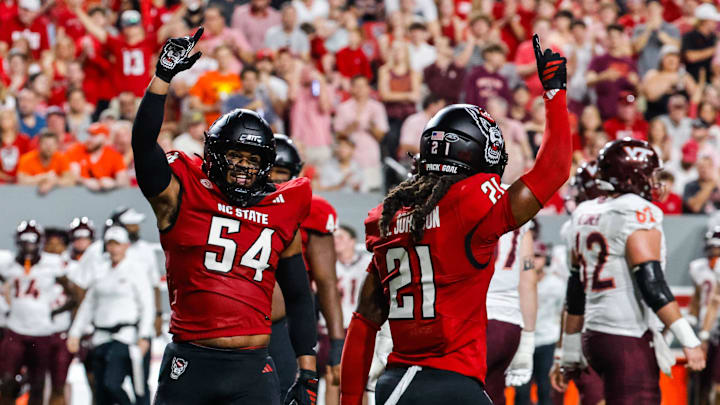 Sep 27, 2025; Raleigh, North Carolina, USA; North Carolina State Wolfpack defensive end Sabastian Harsh (54) and North Carolina State Wolfpack cornerback Jamel Johnson (21) celebrate during the first half of the game against Virginia Tech Hokies at Carter-Finley Stadium. Mandatory Credit: Jaylynn Nash-Imagn Images Sep 27, 2025; Raleigh, North Carolina, USA; North Carolina State Wolfpack defensive end Sabastian Harsh (54) and North Carolina State Wolfpack cornerback Jamel Johnson (21) celebrate during the first half of the game against Virginia Tech Hokies at Carter-Finley Stadium. Mandatory Credit: Jaylynn Nash-Imagn Images