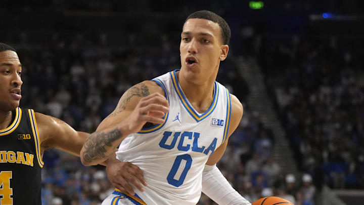 Jan 7, 2025; Los Angeles, California, USA; UCLA Bruins guard Kobe Johnson (0) dribbles the ball against Michigan Wolverines guard Nimari Burnett (4) in the second half at Pauley Pavilion presented by Wescom. Mandatory Credit: Kirby Lee-Imagn Images