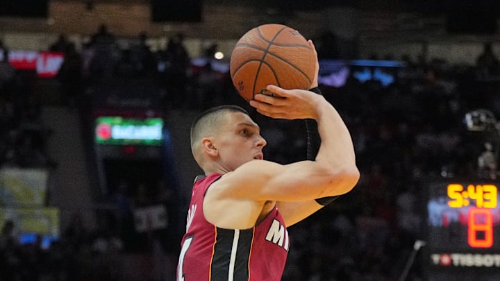 Nov 29, 2024; Miami, Florida, USA;  Miami Heat guard Tyler Herro (14) take three-point shot as Toronto Raptors guard Davion Mitchell (45) closes in during the second half in an NBA Cup game at Kaseya Center. Mandatory Credit: Jim Rassol-Imagn Images