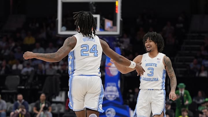 Mar 12, 2025; Charlotte, NC, USA; North Carolina Tar Heels guard Elliot Cadeau (3) smiles and congrats forward Jae'Lyn Withers (24) after another long three point shot against the Notre Dame Fighting Irish during the second half at Spectrum Center. Mandatory Credit: Jim Dedmon-Imagn Images
