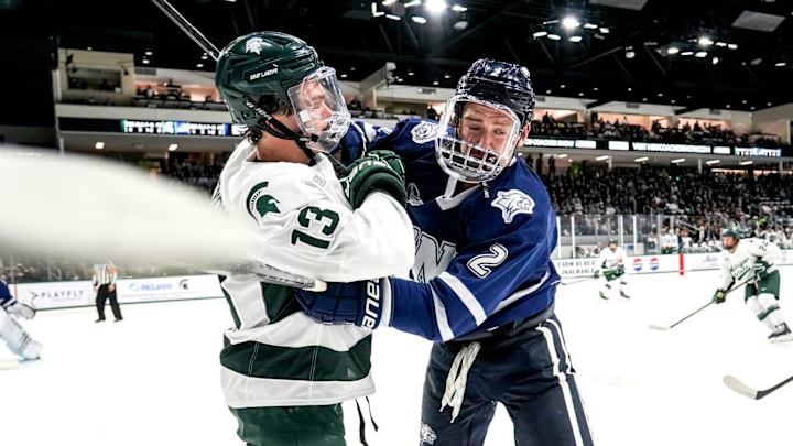 Michigan State's Tiernan Shoudy, left, battles with New Hampshire's Alex Carr during the first period on Thursday, Oct. 9, 2025, at Munn Ice Arena in East Lansing.