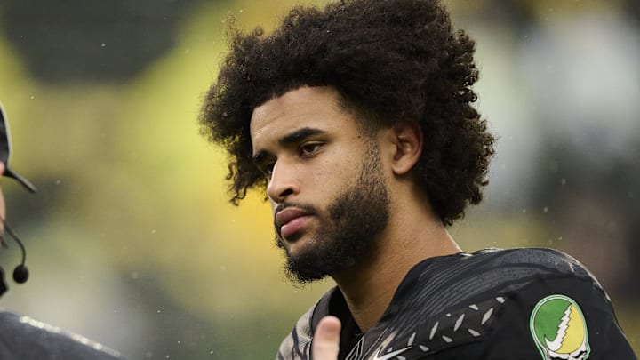 Oct 25, 2025; Eugene, Oregon, USA; Oregon Ducks quarterback Dante Moore (5) talks to officials during warm ups before a game against the Wisconsin Badgers at Autzen Stadium. The Ducks are wearing uniforms celebrating the Grateful Dead. Mandatory Credit: Troy Wayrynen-Imagn Images