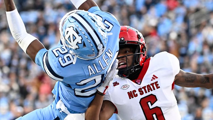 Nov 30, 2024; Chapel Hill, North Carolina, USA; North Carolina Tar Heels defensive back Marcus Allen (29) intercepts the ball in the end zone intended for North Carolina State Wolfpack wide receiver Wesley Grimes (6) in the first quarter at Kenan Memorial Stadium. Mandatory Credit: Bob Donnan-Imagn Images Nov 30, 2024; Chapel Hill, North Carolina, USA; North Carolina Tar Heels defensive back Marcus Allen (29) intercepts the ball in the end zone intended for North Carolina State Wolfpack wide receiver Wesley Grimes (6) in the first quarter at Kenan Memorial Stadium. Mandatory Credit: Bob Donnan-Imagn Images