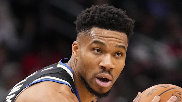 Milwaukee Bucks forward Giannis Antetokounmpo holds the ball away from Denver Nuggets forward Aaron Gordon.