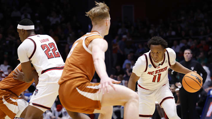 Mar 17, 2026; Dayton, OH, USA; NC State Wolfpack guard Quadir Copeland (11) dribbles the ball defended by Texas Longhorns center Matas Vokietaitis (8) in the first half during a first four game of the men's 2026 NCAA Tournament at University of Dayton Arena. Mandatory Credit: Rick Osentoski-Imagn Images